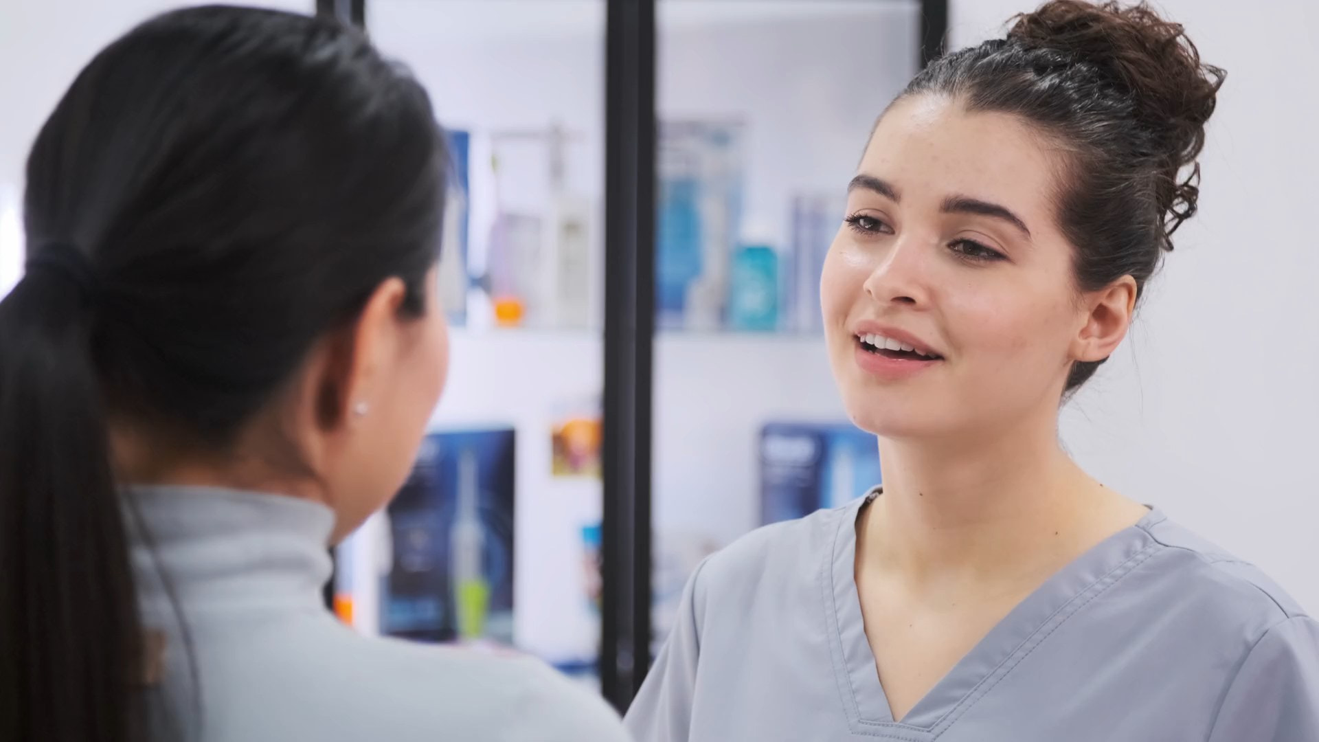 Clinician in grey scrubs in a bright clinic